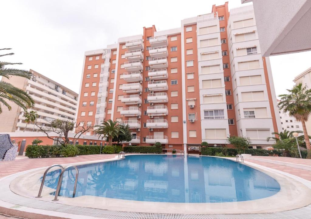 une grande piscine en face d'un bâtiment dans l'établissement Apartamentos Marblau Las Alondras-Julio y Agosto SOLO FAMILIAS, à Gandía