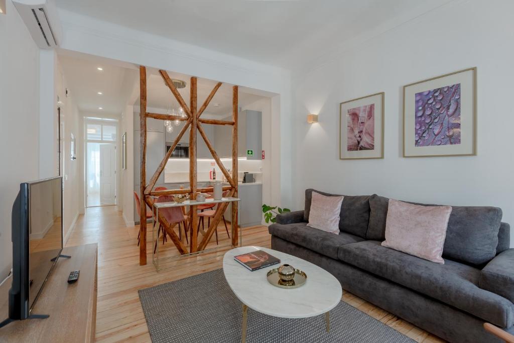 ein Wohnzimmer mit einem Sofa und einem Tisch in der Unterkunft Príncipe Real Flamingo Residence in Lissabon