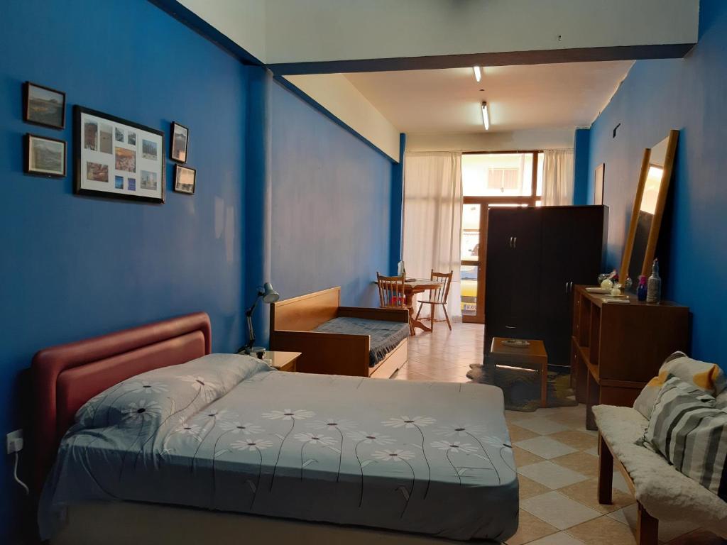 a bedroom with a bed and a blue wall at Studio BLU in Xylophaghou