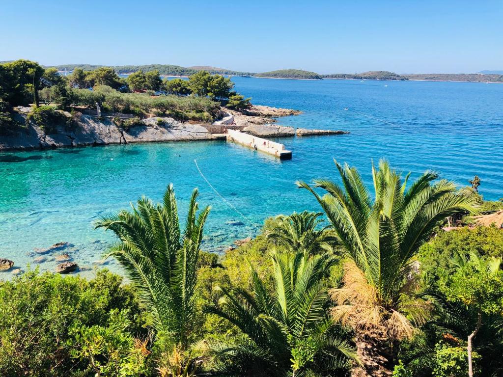 a view of a body of water with palm trees at Apartment Shades of Blue in Hvar