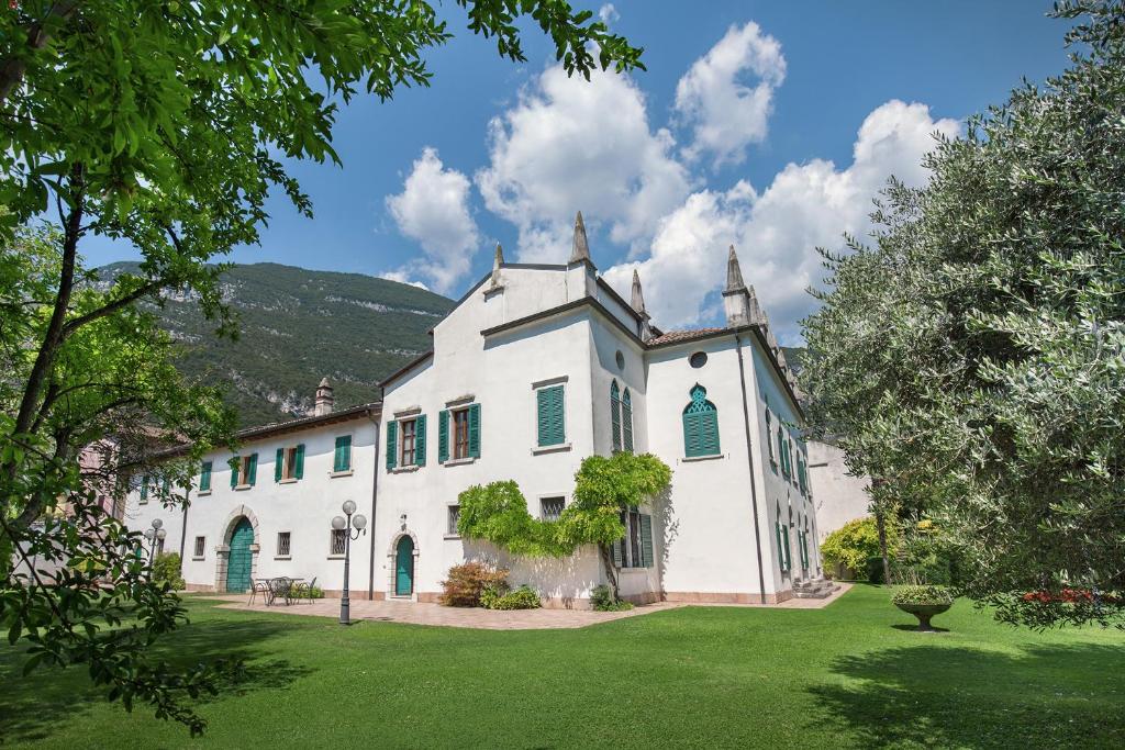 a large white house with a green yard at Villa Brignoli in Rivalta di Brentino