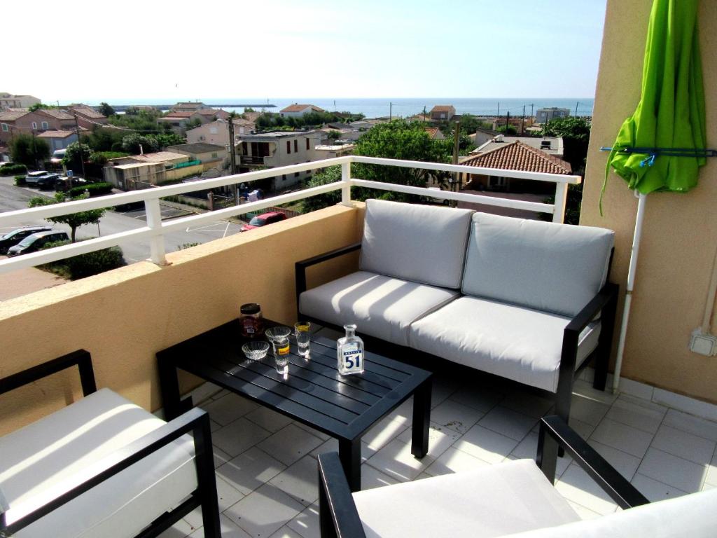 einen Balkon mit 2 Stühlen und einem Tisch mit Aussicht in der Unterkunft Appartement Grand Calypso in Frontignan