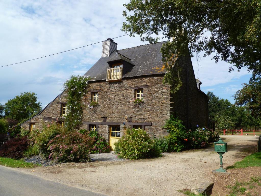 Les Fougerêts的住宿－Chambre d'hôtes Saint Jacob Relais de Chasse du XVIII Siècle，大型砖屋,设有窗户和阳台