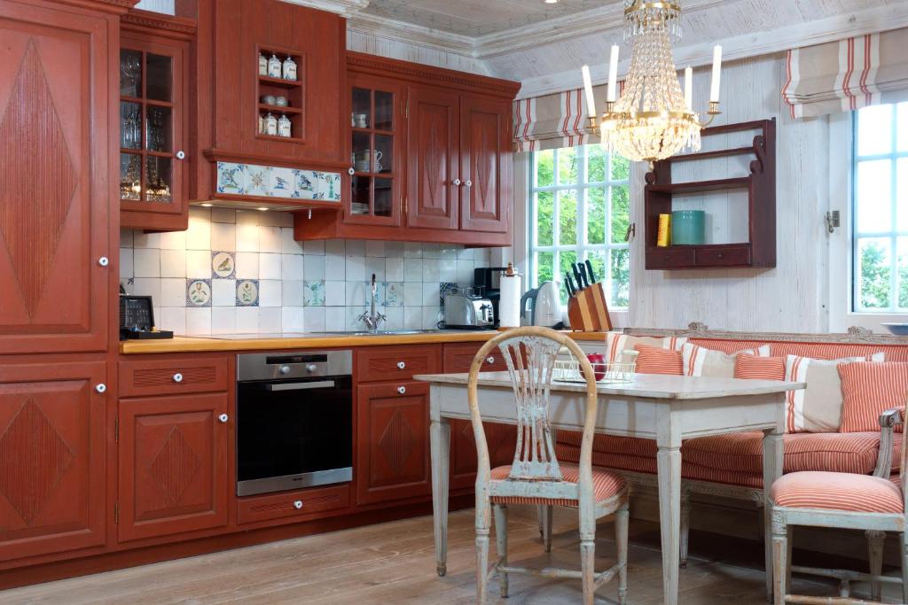 a kitchen with wooden cabinets and a table with chairs at Ferienwohnung am Tipkenhoog 16 in Keitum