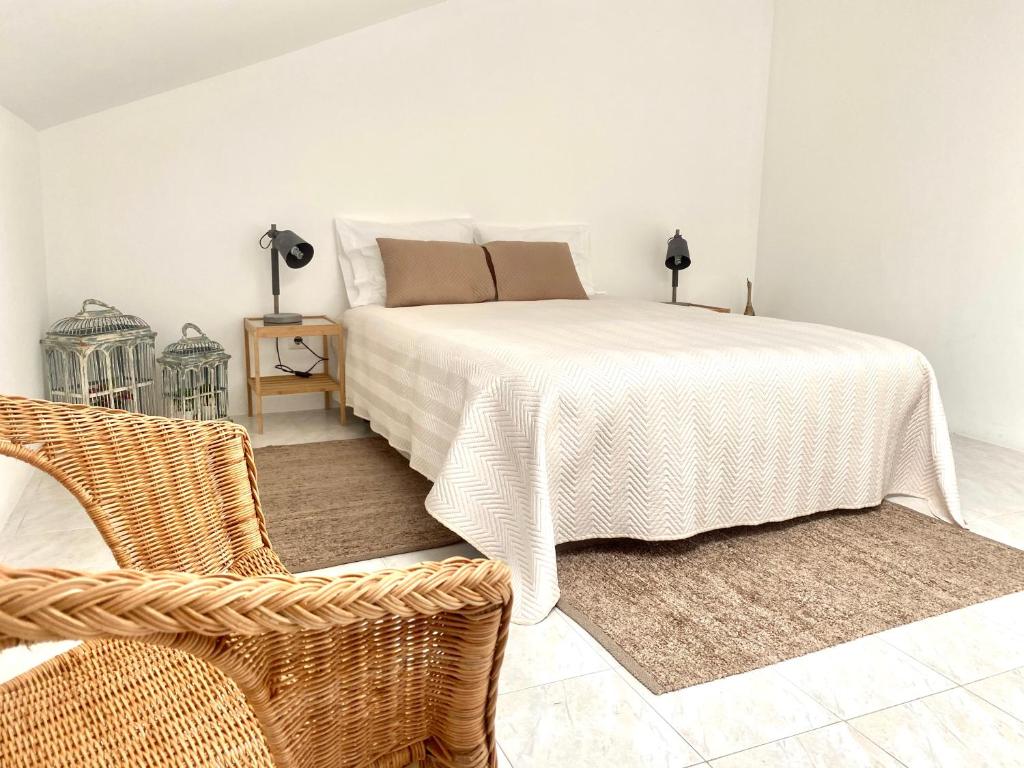 ナザレにあるBrick Ocean Apartmentのベッドルーム(白いベッド1台、椅子付)