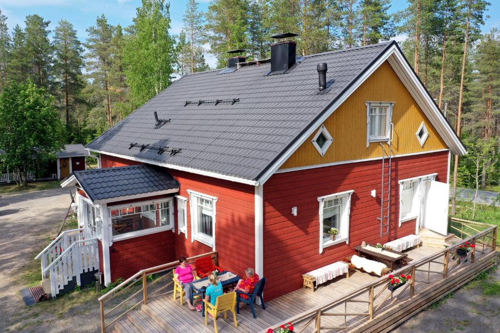 a group of people sitting on the deck of a house at Karkausmäen Kammari in Kinnula