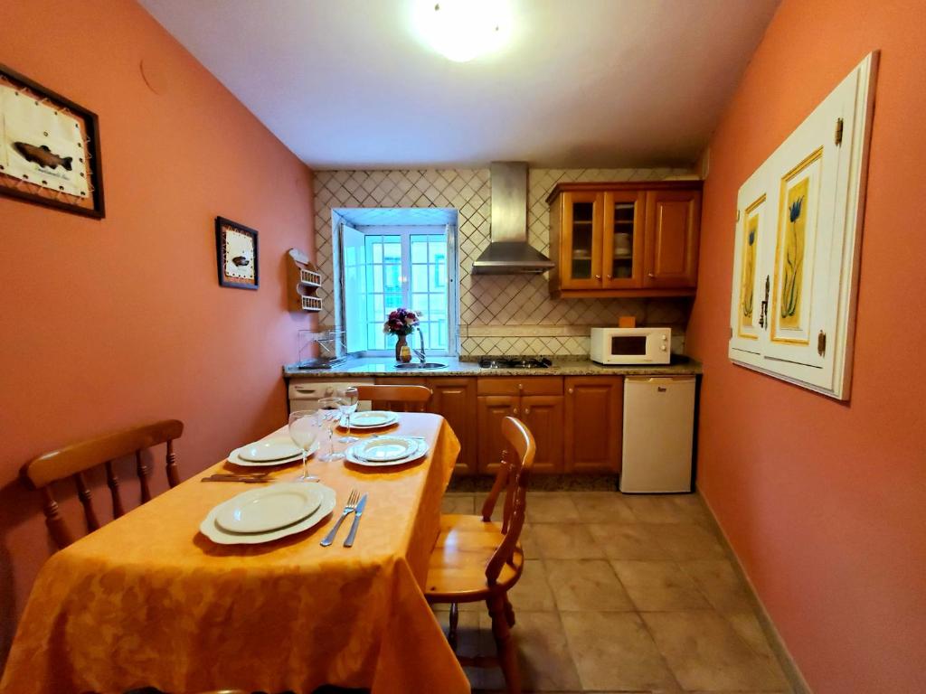 a kitchen with a table and chairs and a kitchen with a table at Apartamentos Turísticos Rosa in Ribadeo