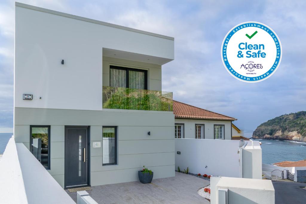 ein Haus mit einem Schild, auf dem steht: in der Unterkunft RR House in Ribeira Quente