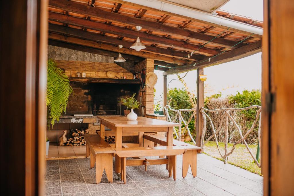 un patio al aire libre con mesa de madera y bancos en Casa do Faial, en Santana