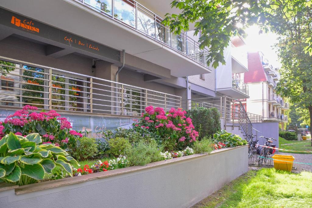 Apartamenty na Wyspie - Feniks - Parking في سفينويتشي: مبنى أمامه زهور ونباتات