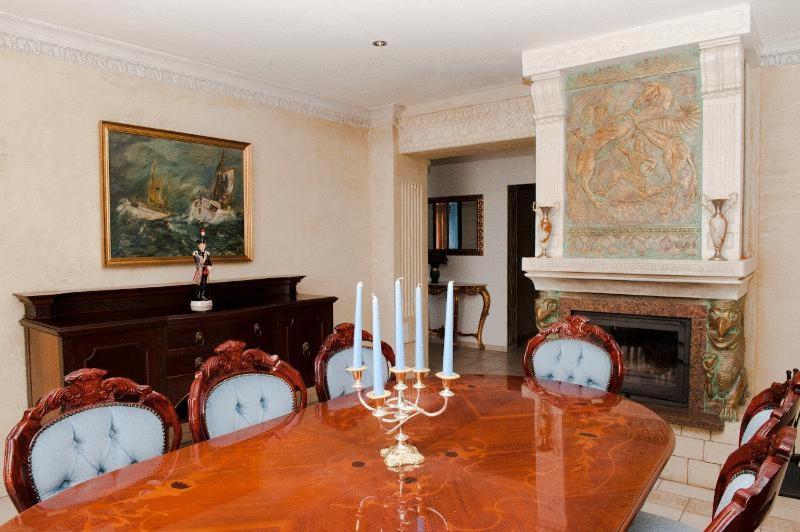 a dining room with a table with chairs and a fireplace at Columba Livia Guesthouse in Palanga