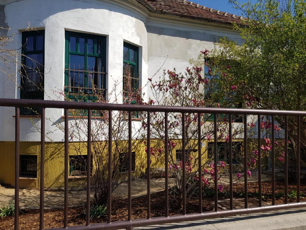 a fence in front of a house with flowers at Borostyánkő Vendégház in Szombathely