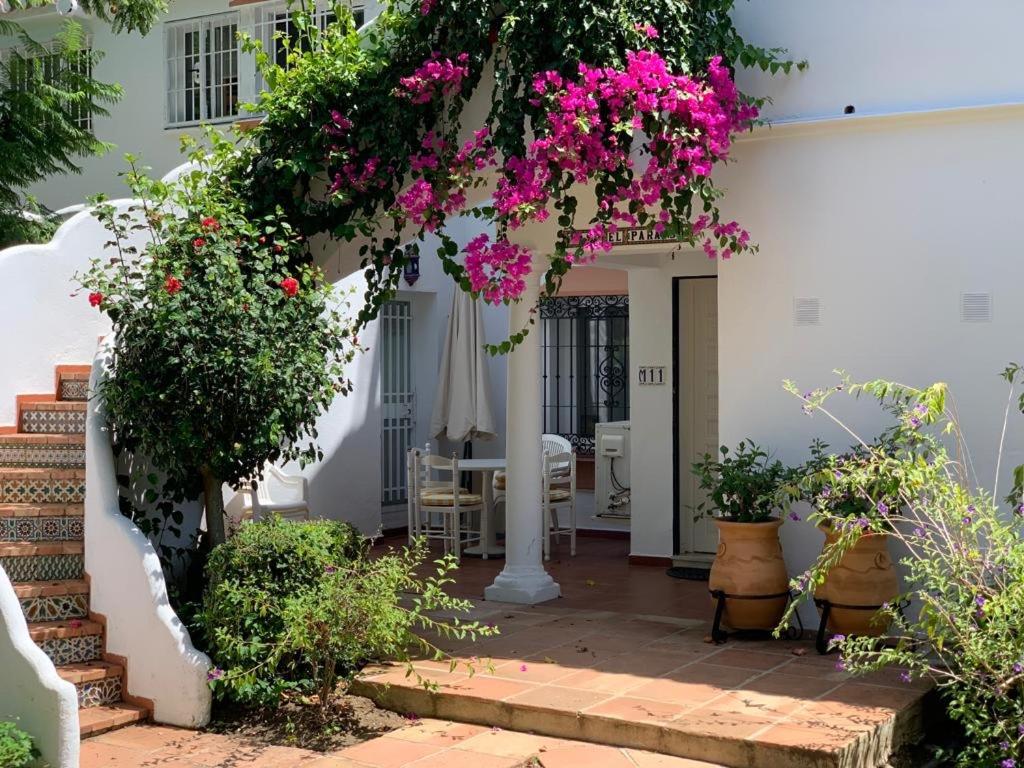 een wit huis met roze bloemen op een binnenplaats bij Casa El Paraiso Marbella in Estepona