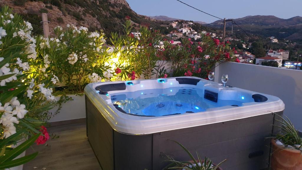 a hot tub on a balcony with flowers at Casa Sofia in Spílion