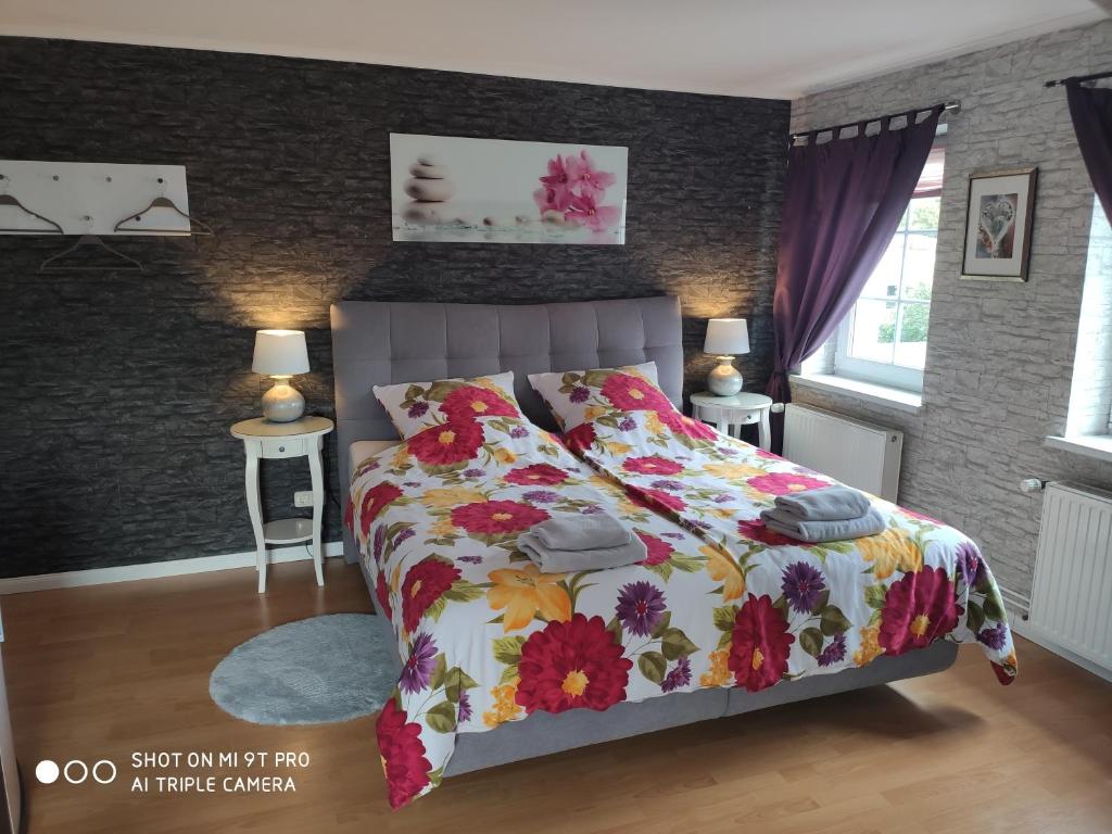 Un dormitorio con una cama con una colcha floral. en Blumen Apartment, en Hamburgo