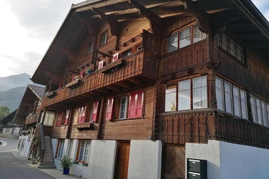 - un bâtiment en bois avec un balcon sur le côté dans l'établissement Ferien im Paradies, à Brienzwiler