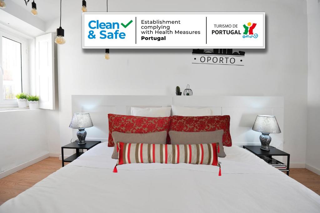 a white bedroom with a white bed with red pillows at 137 Private family home -8 min from historic center in Vila Nova de Gaia