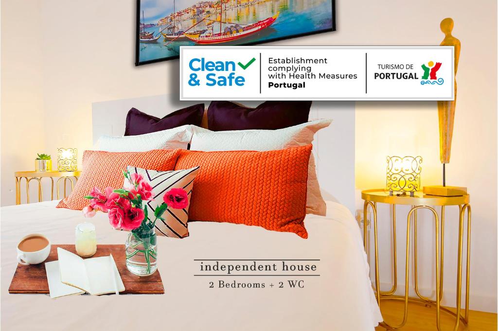 ein Schlafzimmer mit einem Bett mit orangefarbenen und weißen Kissen in der Unterkunft Private House Only For You 133 - 8min historicCenter in Vila Nova de Gaia