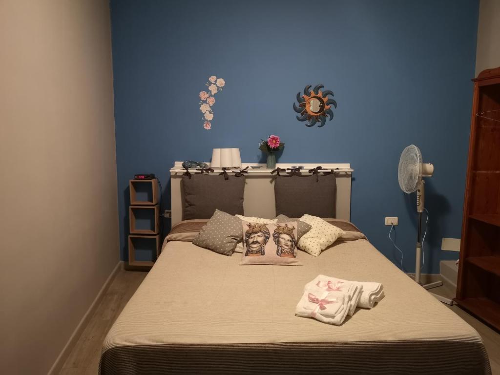 a bedroom with a bed with a blue wall at La casa di Nina in San Giovanni la Punta