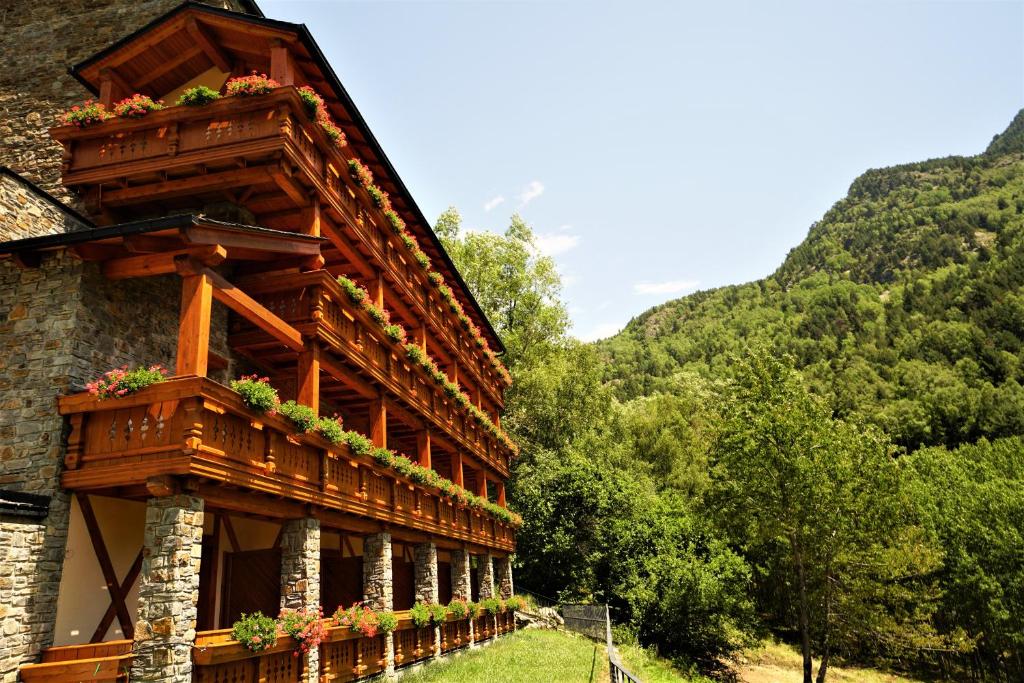 un edificio con un balcón con flores. en Hotel & Spa Xalet Bringue en Ordino