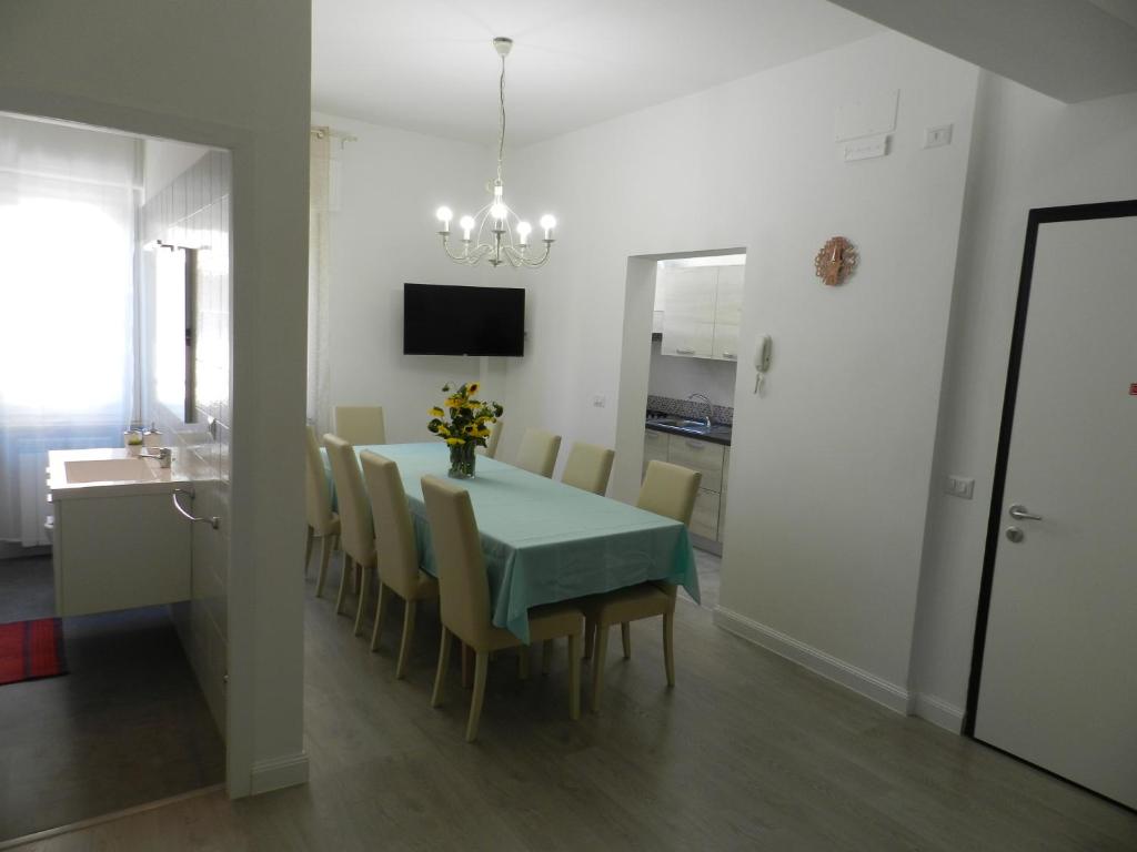 a dining room with a green table and chairs at Appartamenti Via Cortonese 1 in Perugia