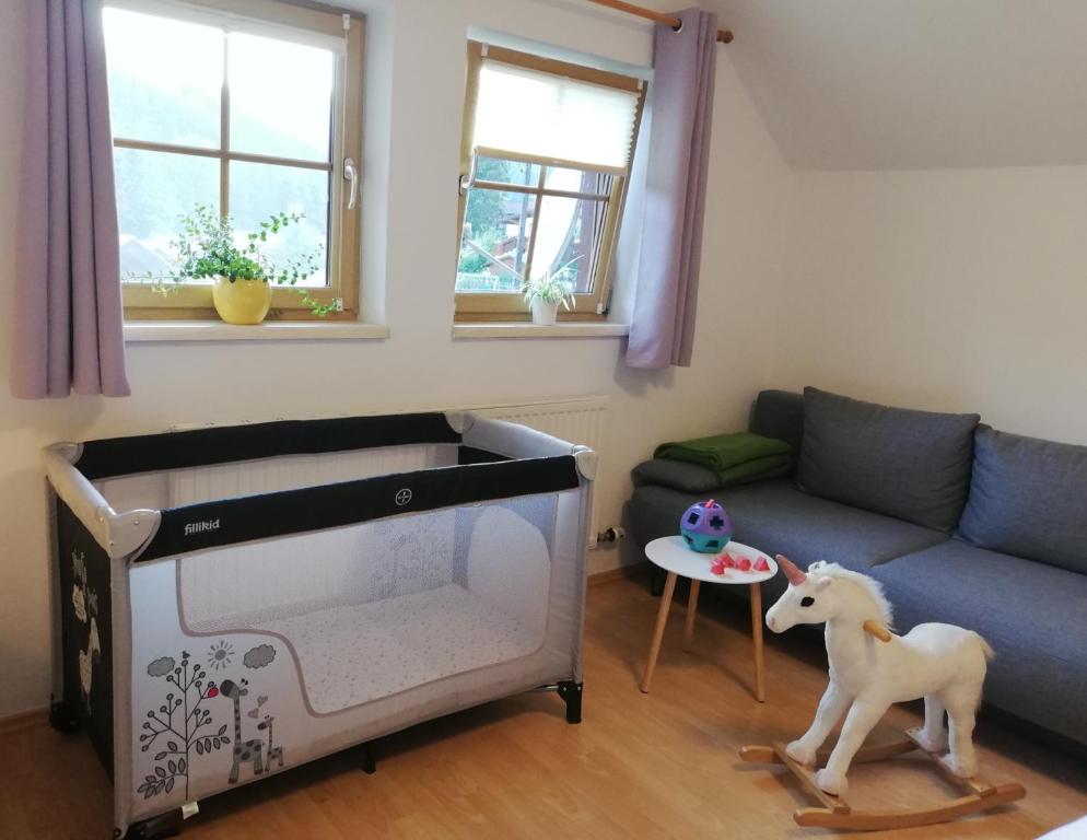 ein Wohnzimmer mit einem Sofa und einem Pferdespielzeug in der Unterkunft Apartment Natur Herz in Haus im Ennstal