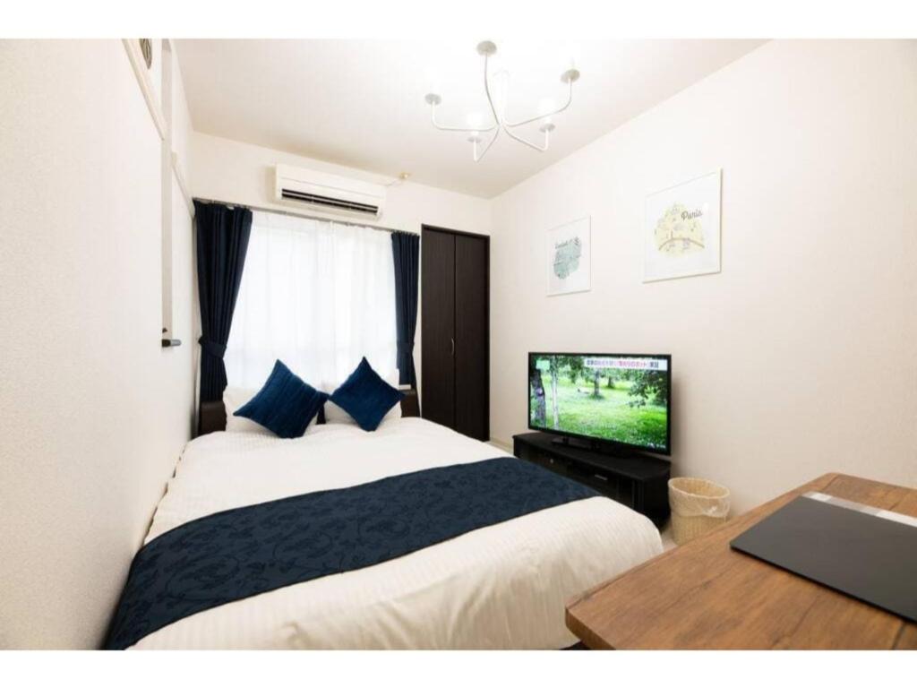 - une chambre avec un lit, une télévision et une table dans l'établissement BIANCOLINA - Vacation STAY 87604, à Fukuoka