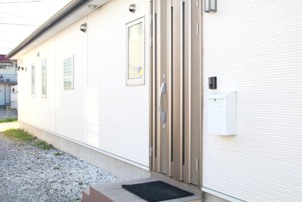 una porta sul lato di un edificio bianco di Chiba - House - Vacation STAY 87410 a Chiba