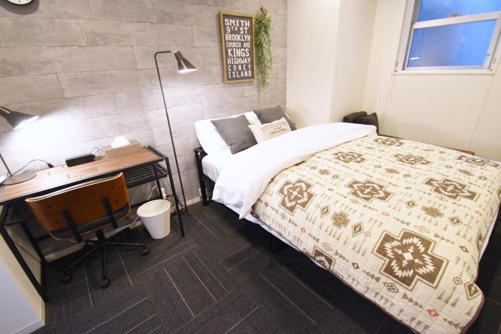 a bedroom with a bed and a desk at REGALO Shibaura - Vacation STAY 87447 in Tokyo