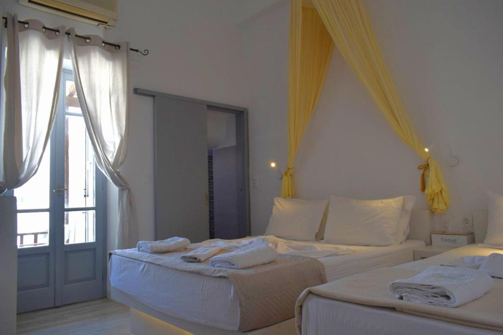 a bedroom with two beds with towels on them at Virginia Rooms in Tinos
