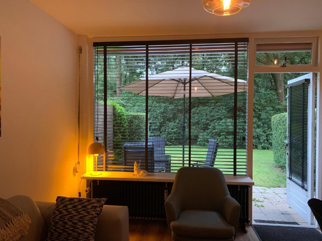uma sala de estar com uma janela com um guarda-chuva em De Spitse Egel: ontdek de pareltjes in de natuur! em Otterlo