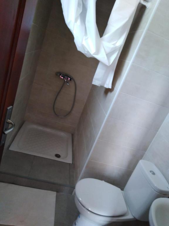 Un pequeño baño con inodoro y ducha. en El sueño - Le rêve, en San Bartolomé