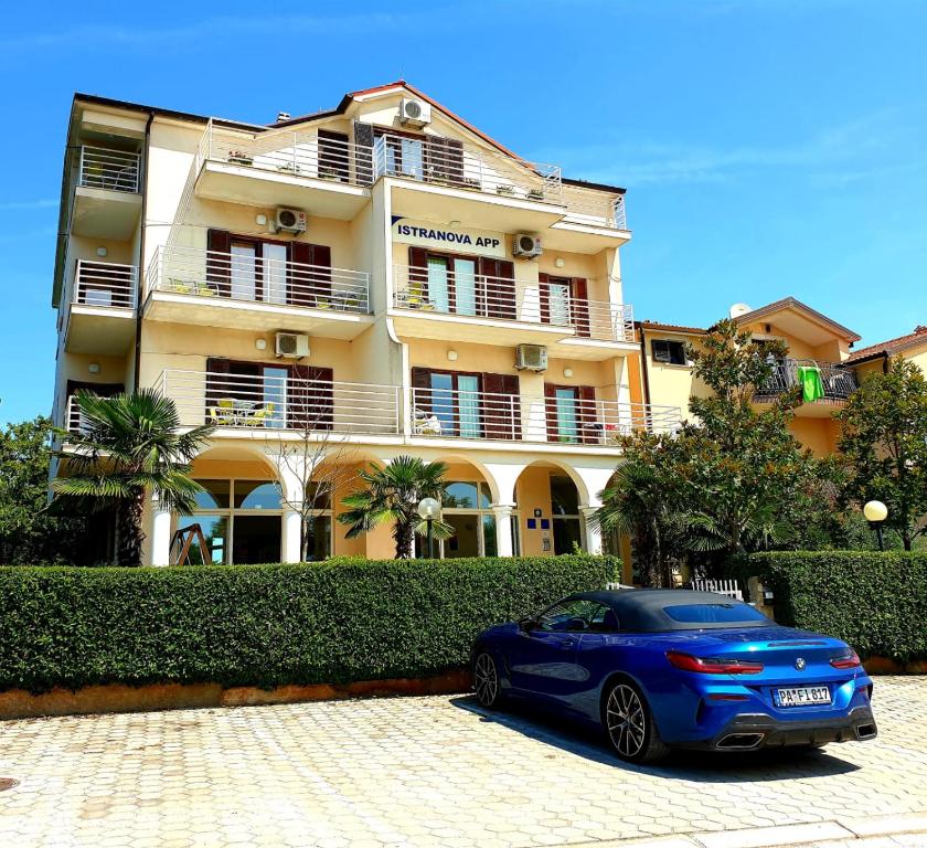 um carro azul estacionado em frente a um edifício em IstraNova Apartments em Rovinj