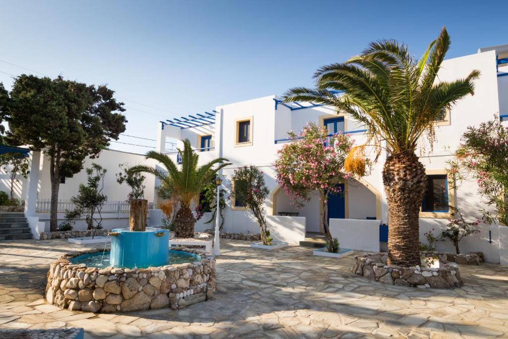 une cour avec des palmiers et un bâtiment dans l'établissement Summer Breeze, à Arkasa