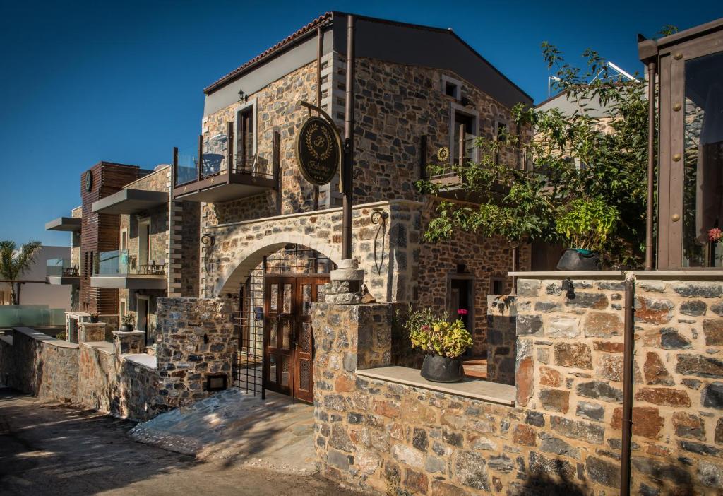 a stone building with an archway in a street at Balsamico Traditional Suites in Hersonissos
