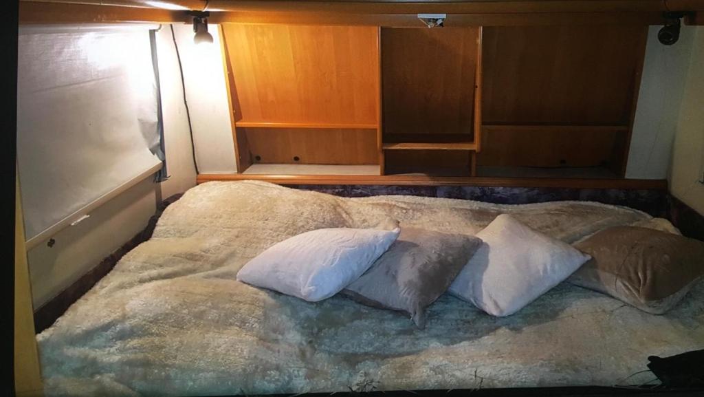 duże łóżko z 3 poduszkami na górze w obiekcie Caravane à louer w mieście Sennecey-le-Grand