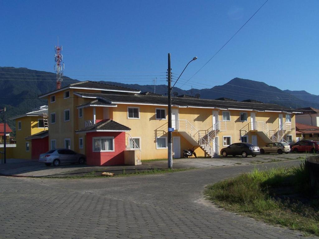 a group of houses on a street with mountains in the background at Villagio Verde Mare in Caraguatatuba