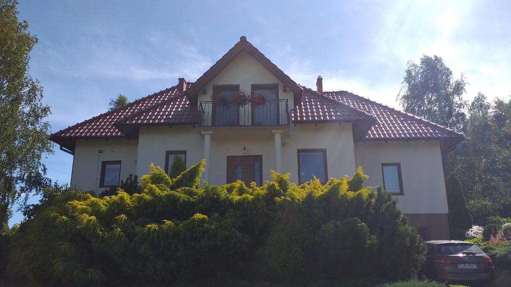 a house with a balcony with flowers on it at Przytulne Studio Borówkowy Zagajnik in Piechowice
