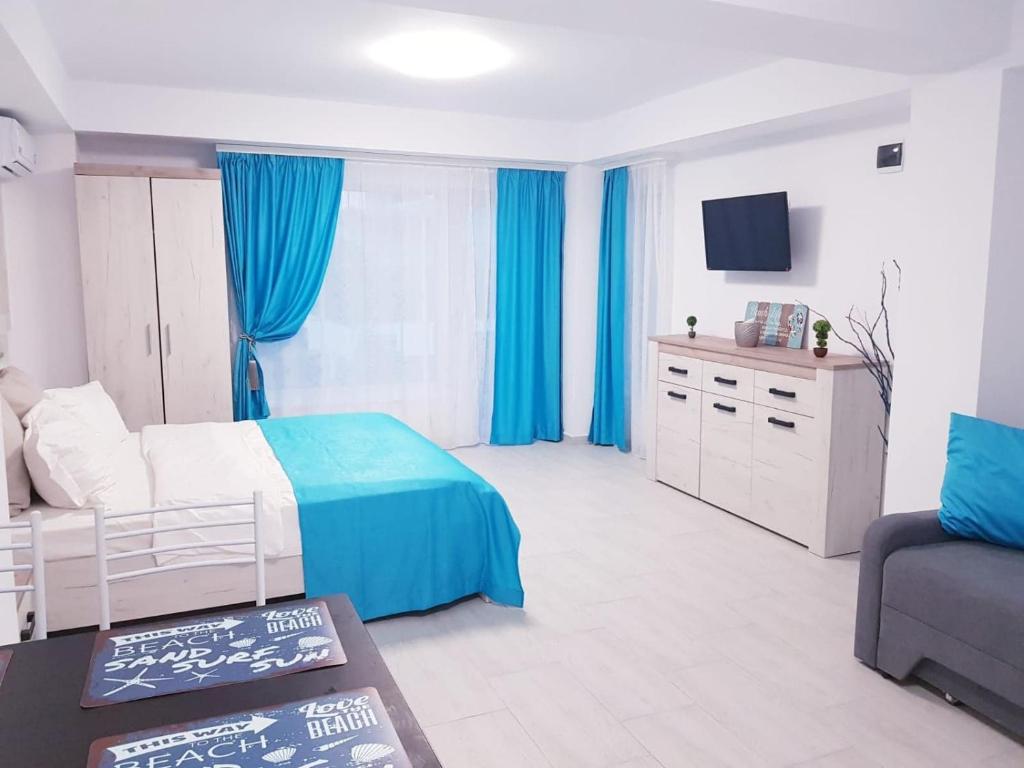 康斯坦察的住宿－Casa Muncel，一间卧室配有蓝色窗帘、一张床和一张沙发