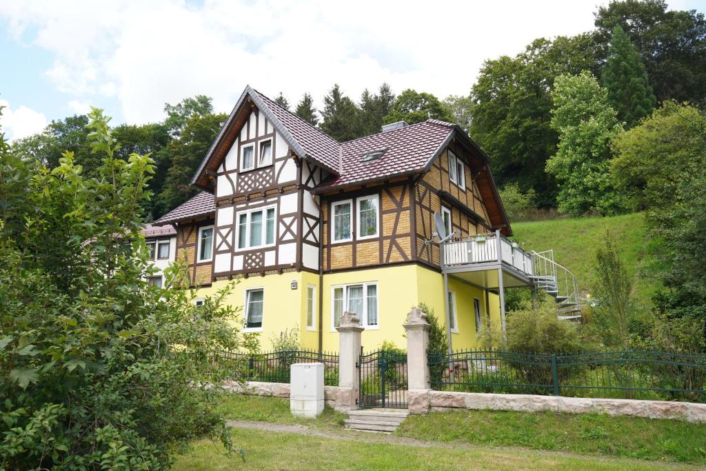 ein gelbes und braunes Haus mit einem Zaun in der Unterkunft Ferienwohnung Sabine in Schmalkalden