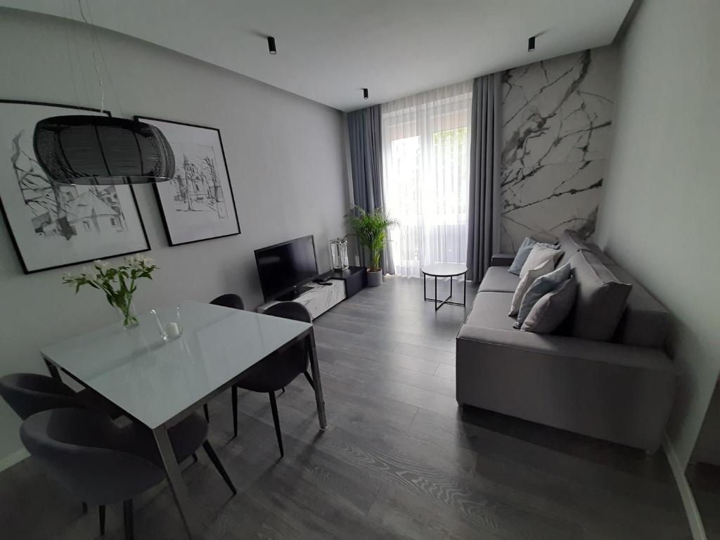 salon z kanapą i stołem w obiekcie Apartament 63 w mieście Częstochowa