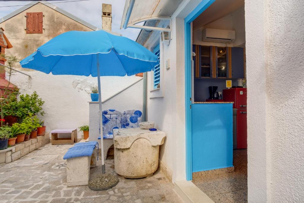 een blauwe paraplu buiten een gebouw bij Apartments Kaštel in Veli Lošinj