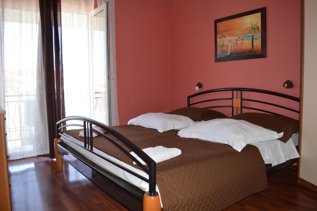 a bedroom with a bed in a room with red walls at Goga Apartments in Primošten