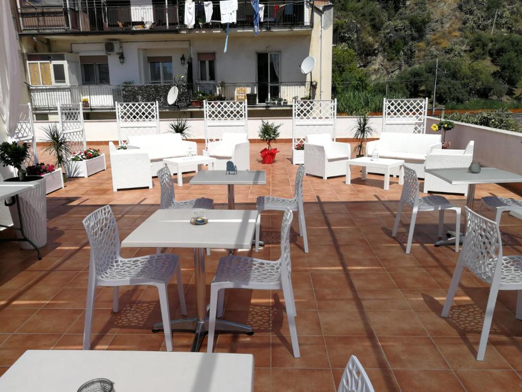 a patio with tables and chairs on a roof at B&B Il Mare degli Dei in Letojanni