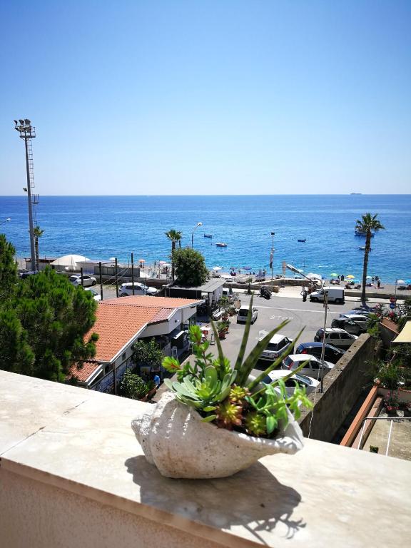 a planter on a ledge with a view of the ocean at B&B Il Mare degli Dei in Letojanni