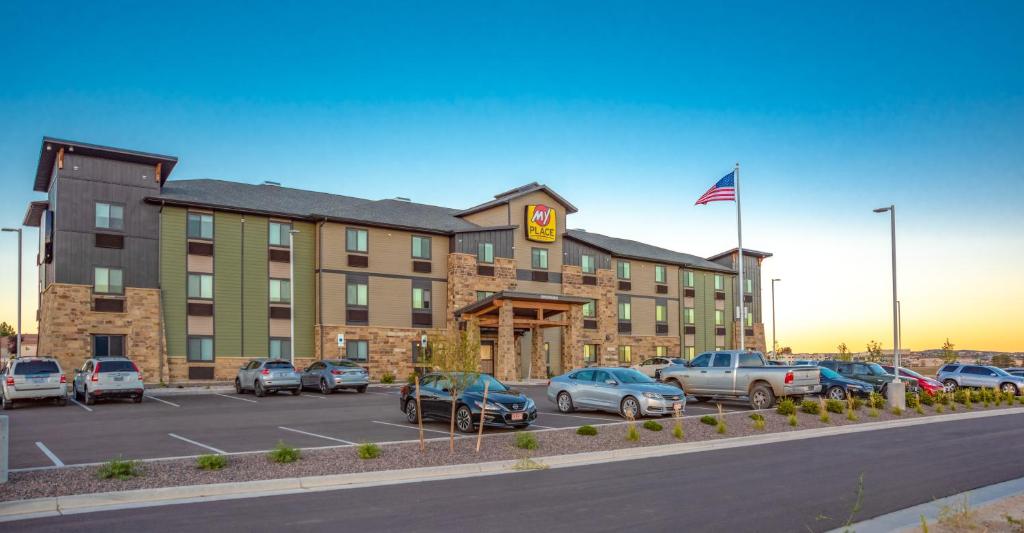 un grand bâtiment avec des voitures garées dans un parking dans l'établissement My Place Hotel-Green Bay, WI, à Green Bay