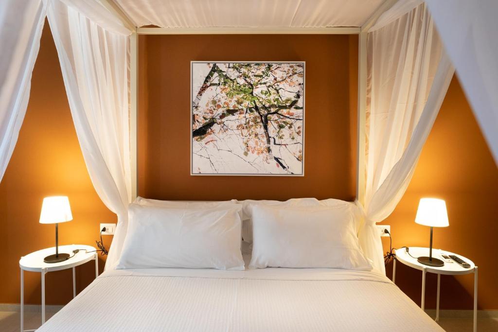 卡塔尼亞的住宿－Sant'Agostino Luxury Apartments，卧室配有带两盏灯的白色床