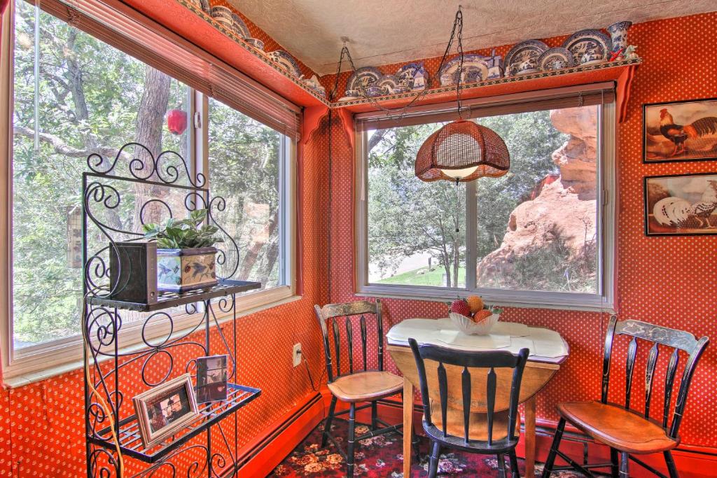 una sala da pranzo con tavolo, sedie e finestre di Colorful Bungalow By Pikes PeakandGarden of the Gods a Manitou Springs