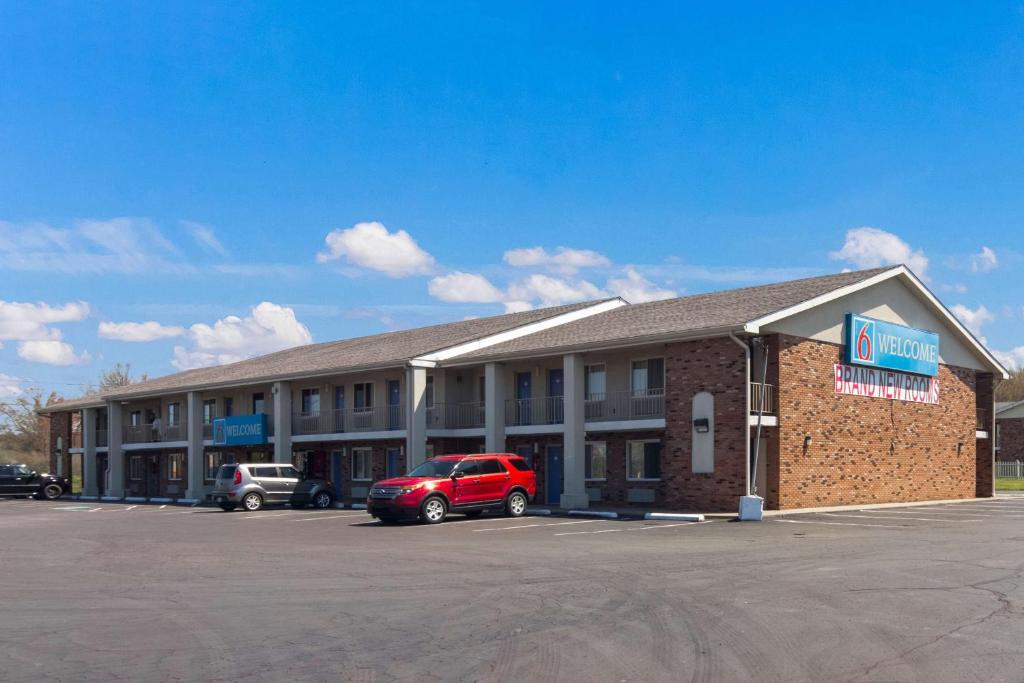 a hotel with a red car parked in a parking lot at Motel 6-Youngstown, OH in Youngstown