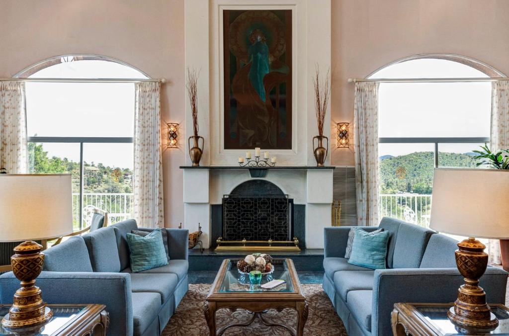 Forest Villas Hotel في بريسكوت: غرفة معيشة مع أرائك زرقاء ومدفأة